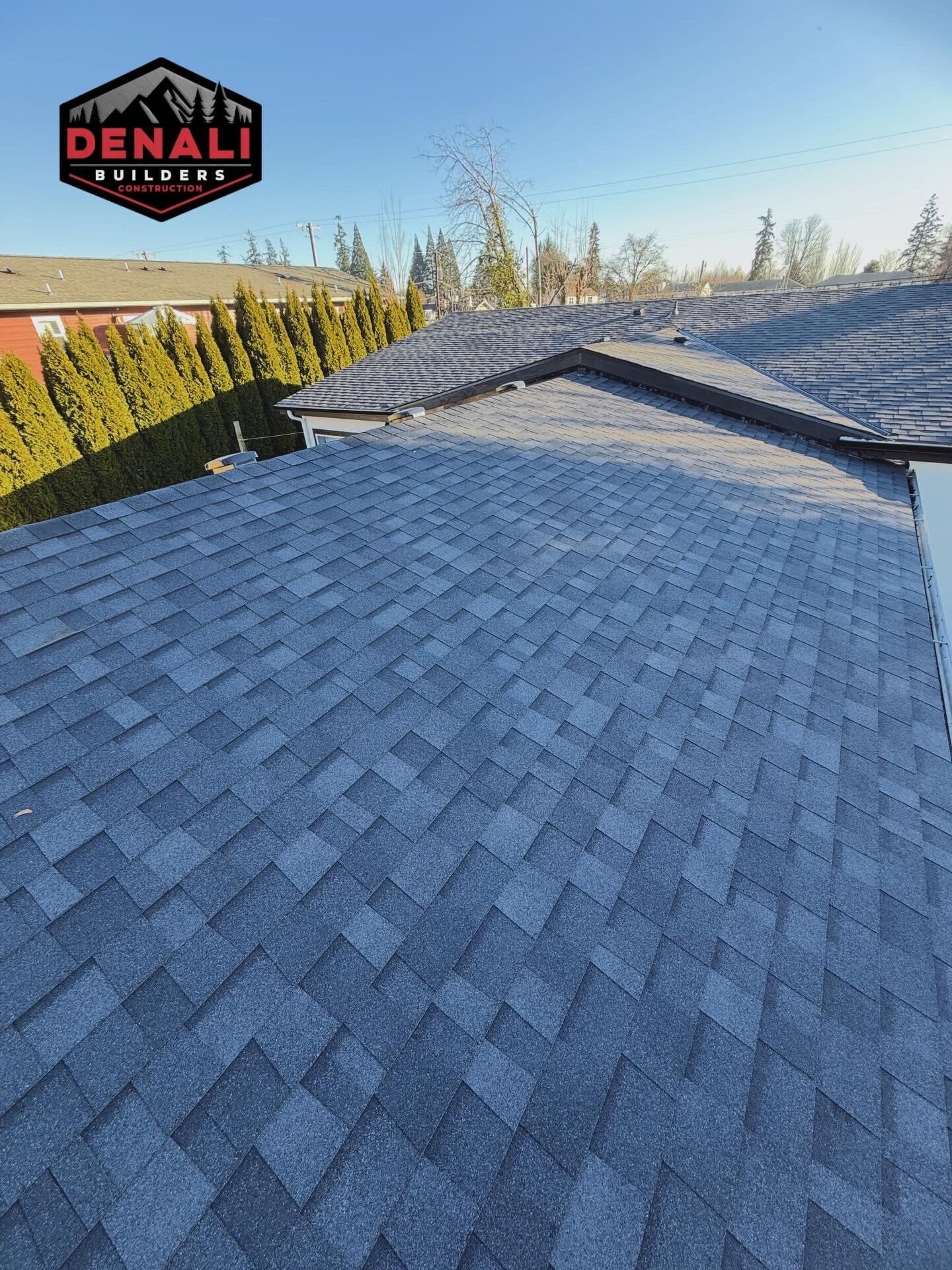 Tall view of new roof shingles and ridge by licensed Oregon roofing contractor
